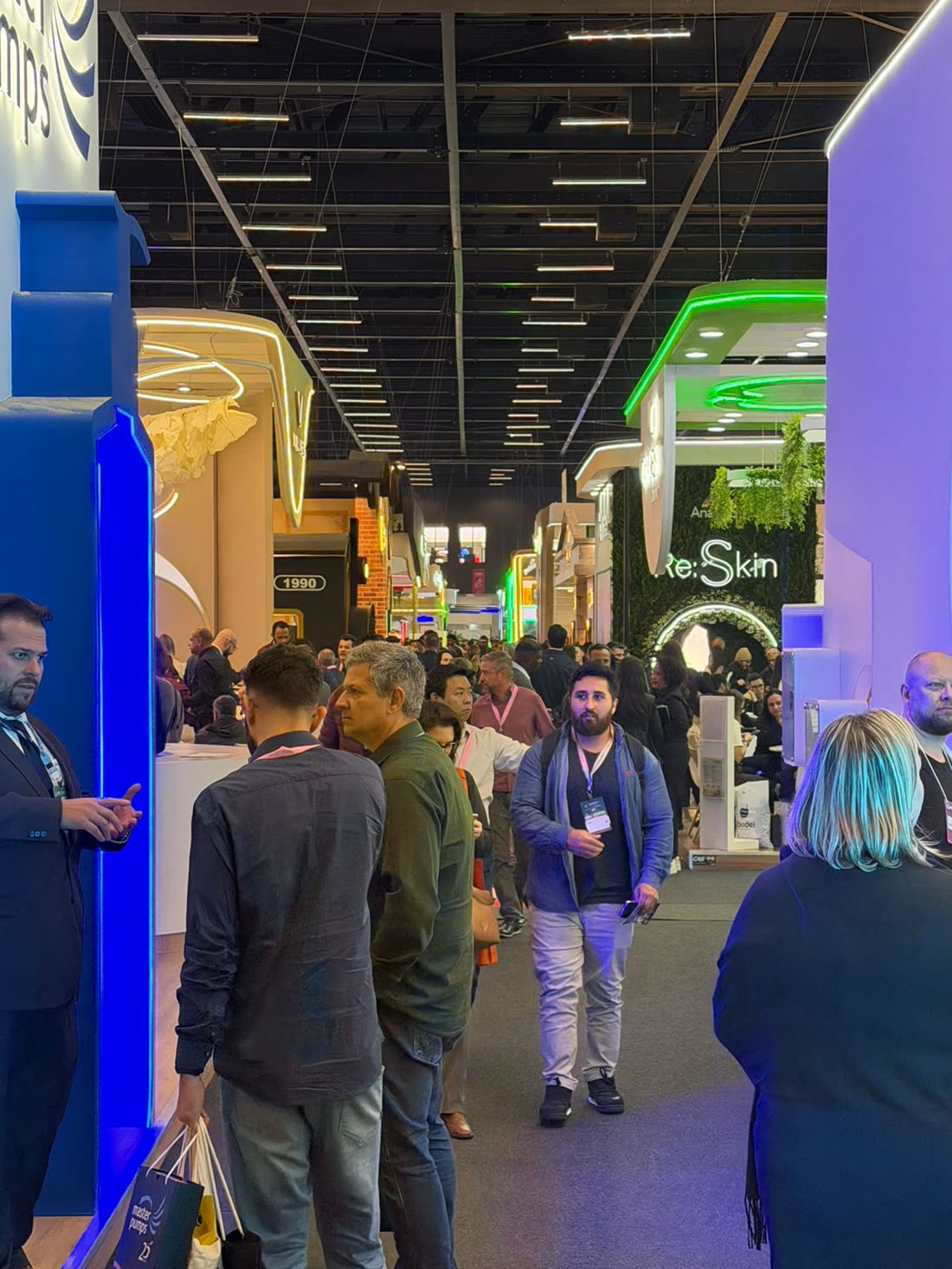 Corredor de pavilhão lotado em feira do setor cosmético
